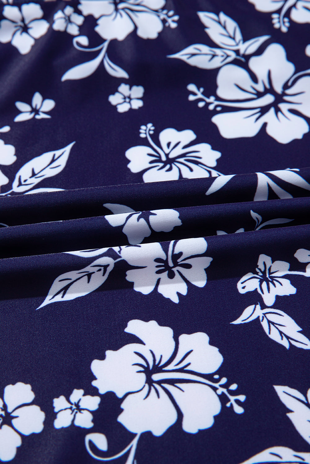 Traje de baño de una pieza con estampado floral, espalda cruzada azul y nudo lateral asimétrico