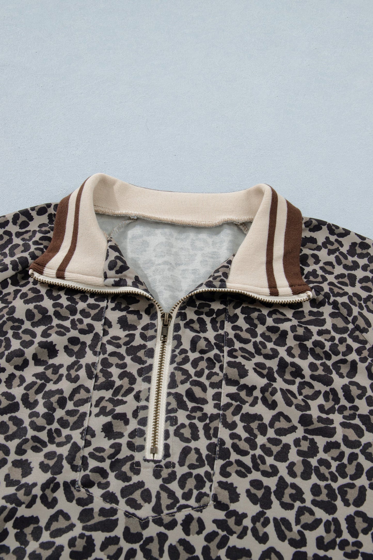 Top de manga corta tipo patchwork con cremallera, cuello alto y estampado de leopardo caqui con ribete a rayas