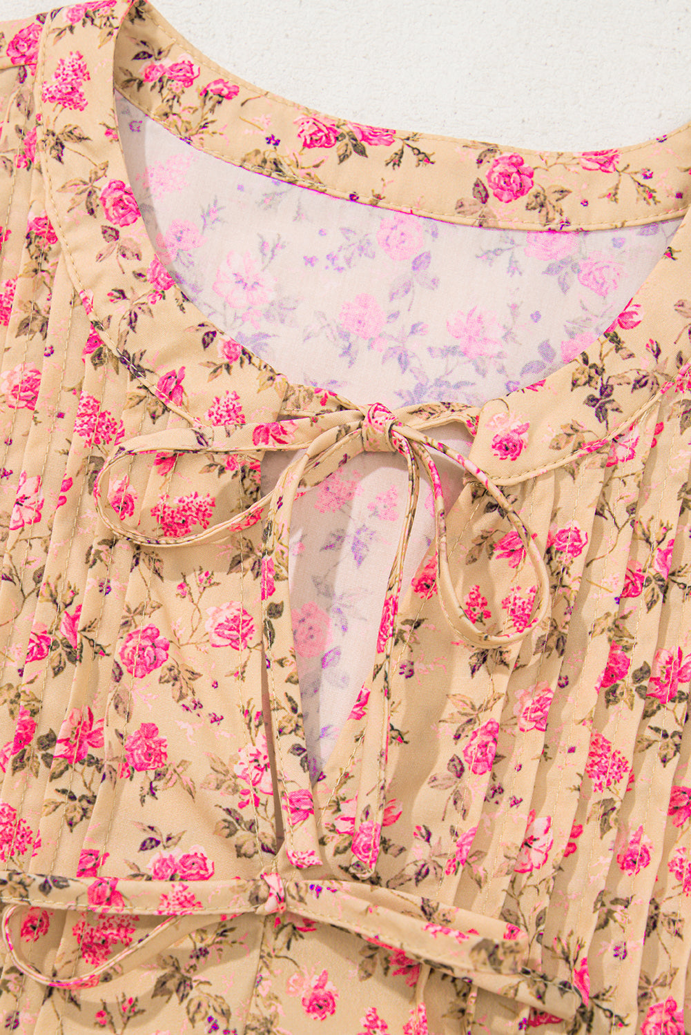 Blusa de color beige francés claro con estampado floral, lazo, pliegues en el busto y media manga abullonada