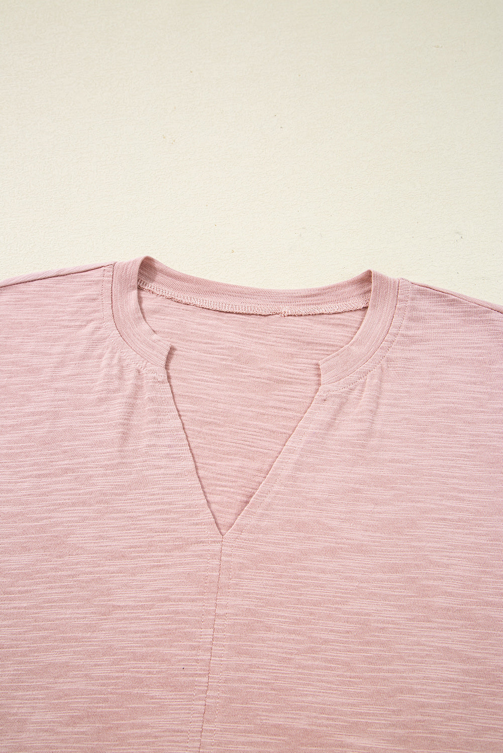 Blusa color rosa claro con escote en V con abertura en la parte delantera y manga murciélago