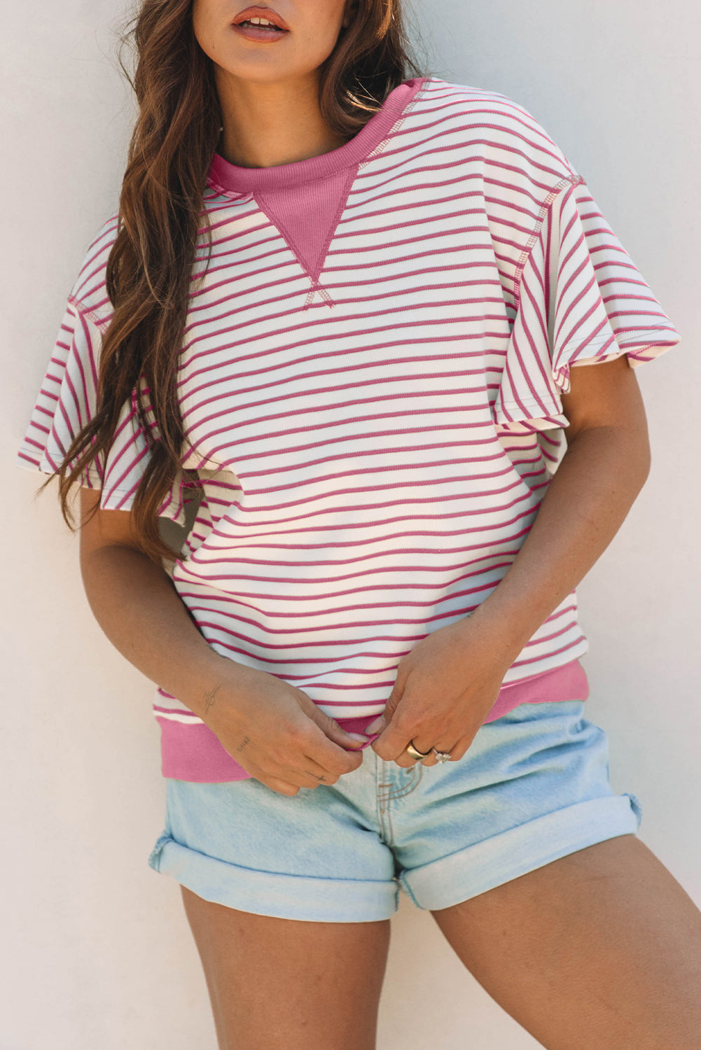 Top de manga corta con volantes a rayas y detalle en contraste rosa sobre rosa