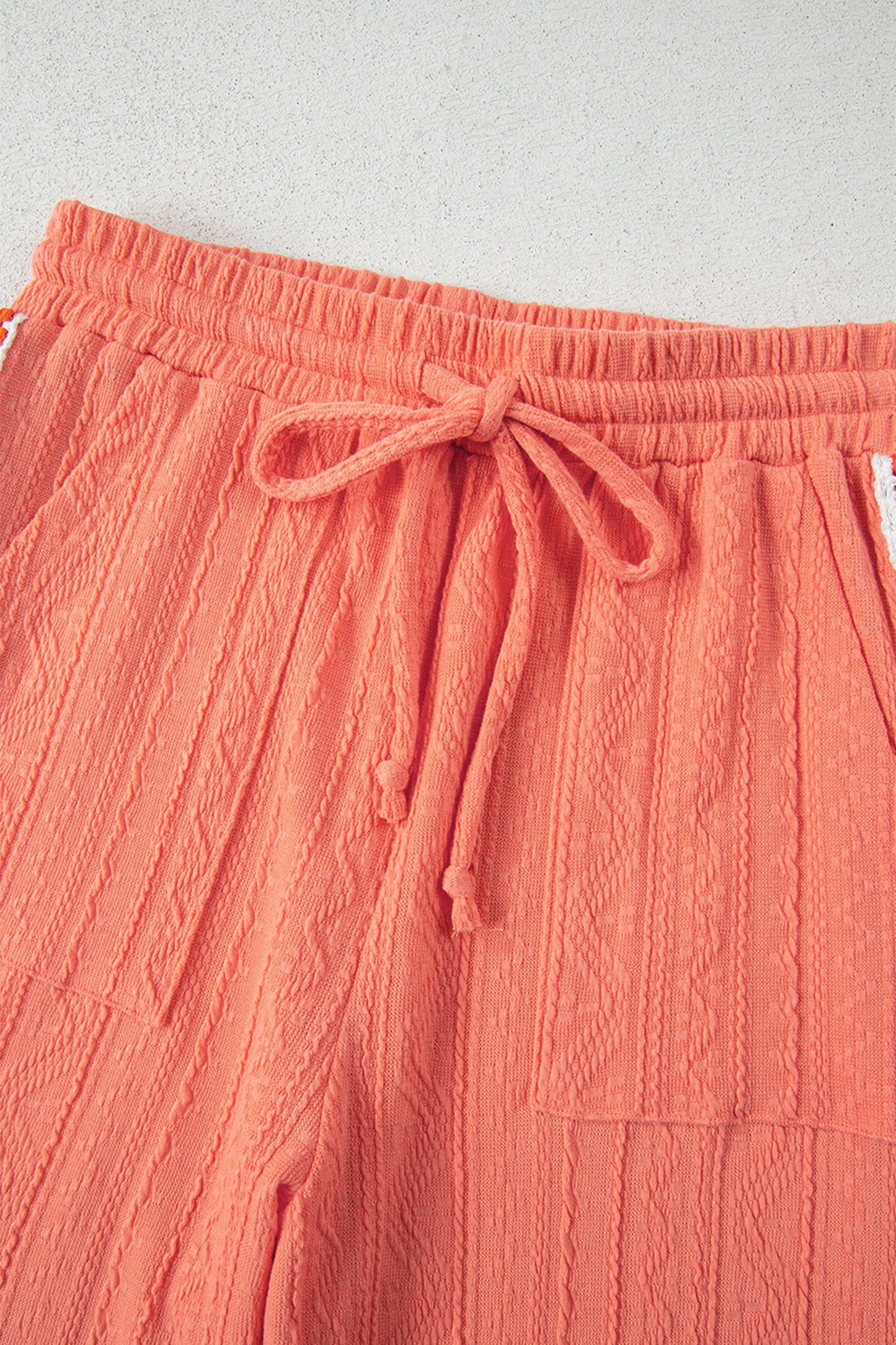 Conjunto de pantalón texturizado con escote en V y detalle floral tejido a ganchillo, color pomelo anaranjado