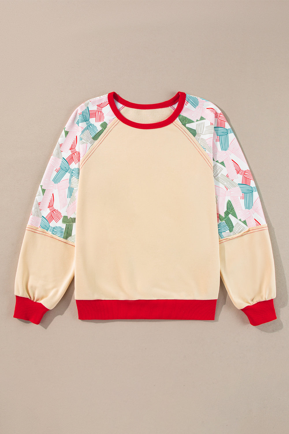 Top beige con lazo estampado, retales, manga raglán y bordes en contraste.