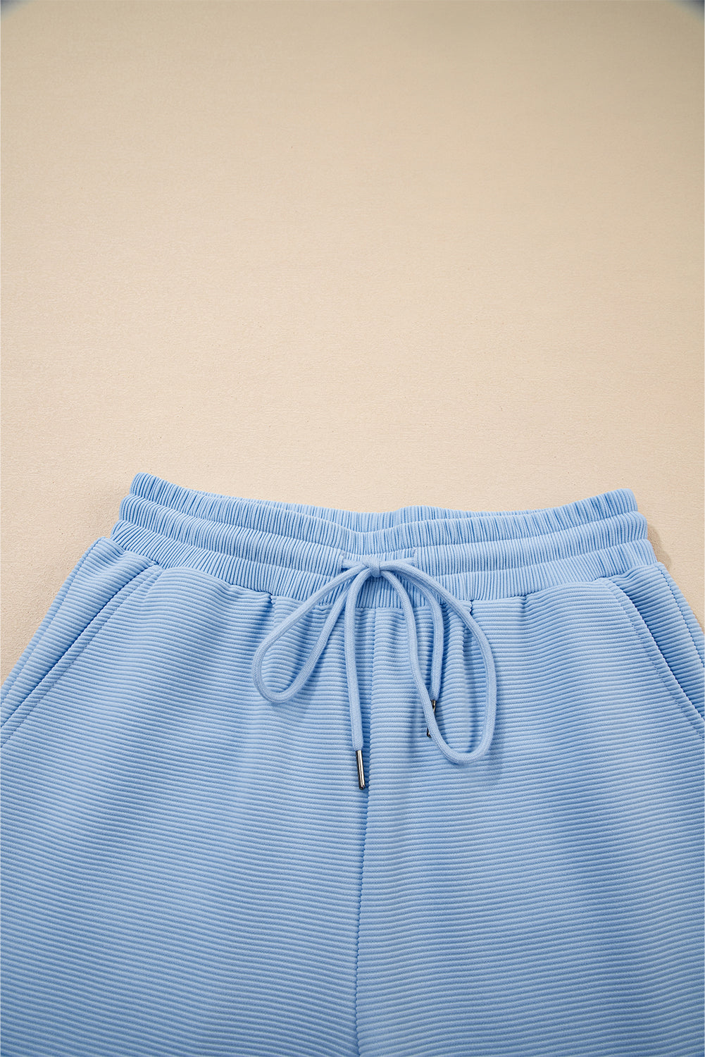 Conjunto de top con cremallera, mangas con volantes y textura azul cielo, y pantalón de pernera ancha