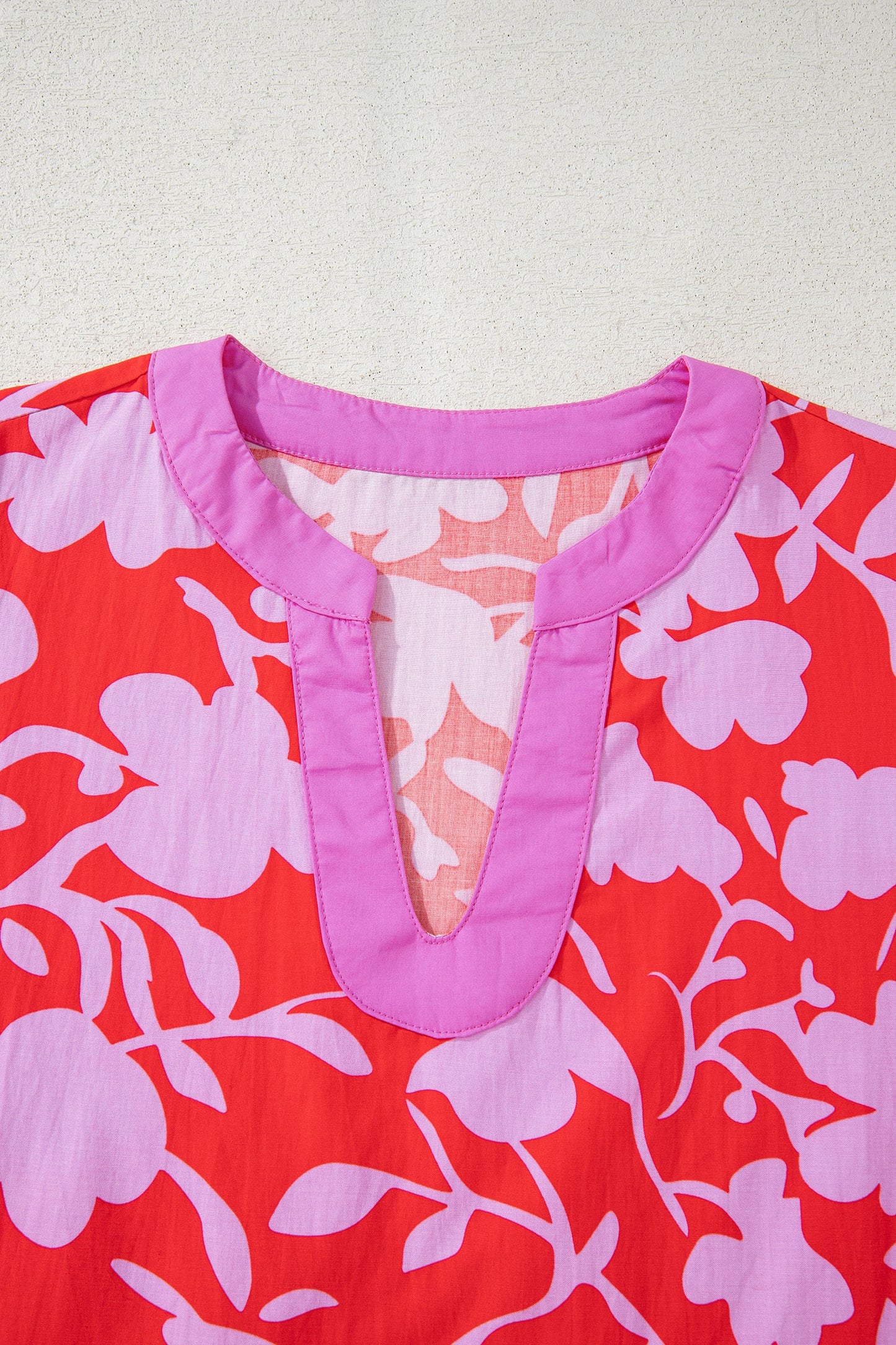 Blusa roja con estampado floral, cuello en V con abertura y manga pulsera con puño