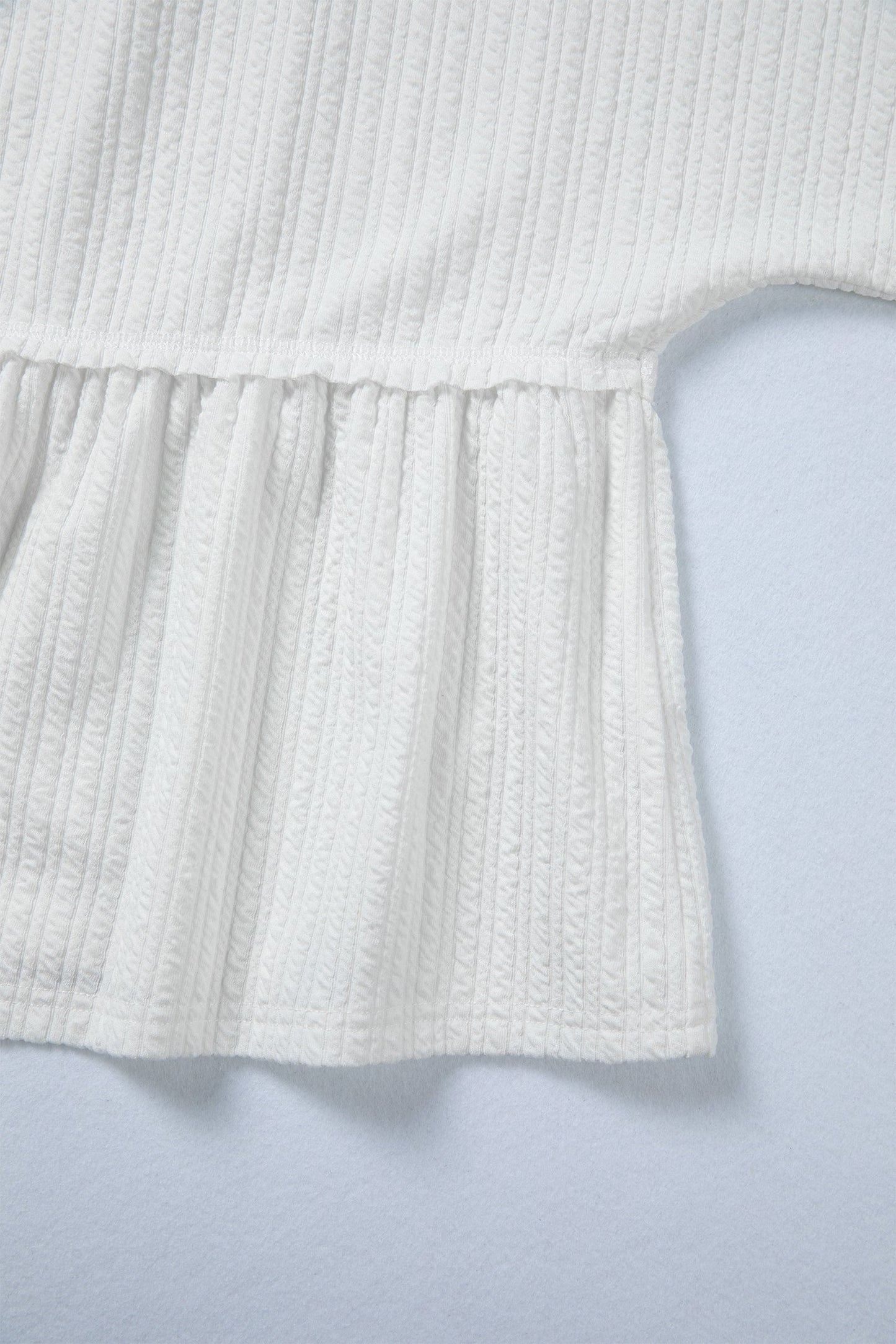 Top peplum de manga larga con hombros caídos texturizado color blanco liso