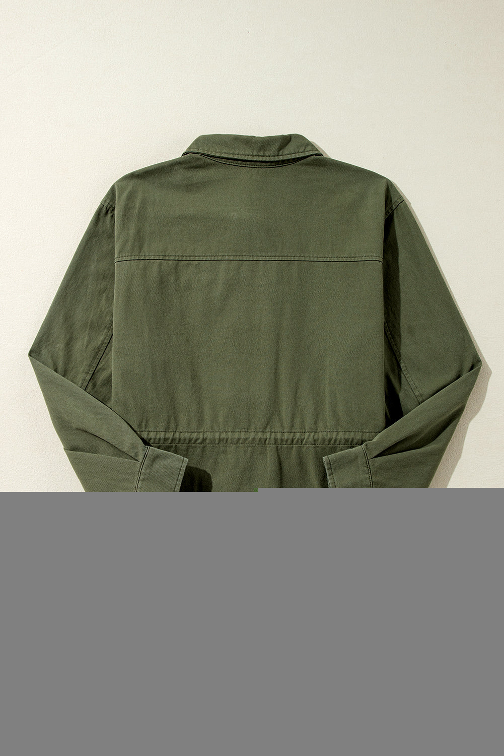 Chaqueta color verde musgo con cremallera, botones a presión, cintura ajustada y cuello.