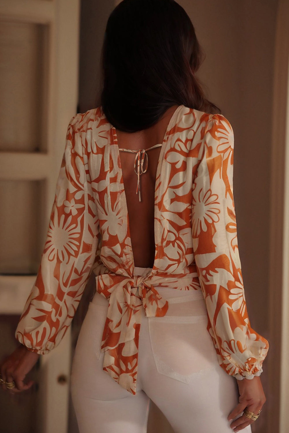 Blusa naranja de manga larga con estampado floral, nudo y espalda abierta