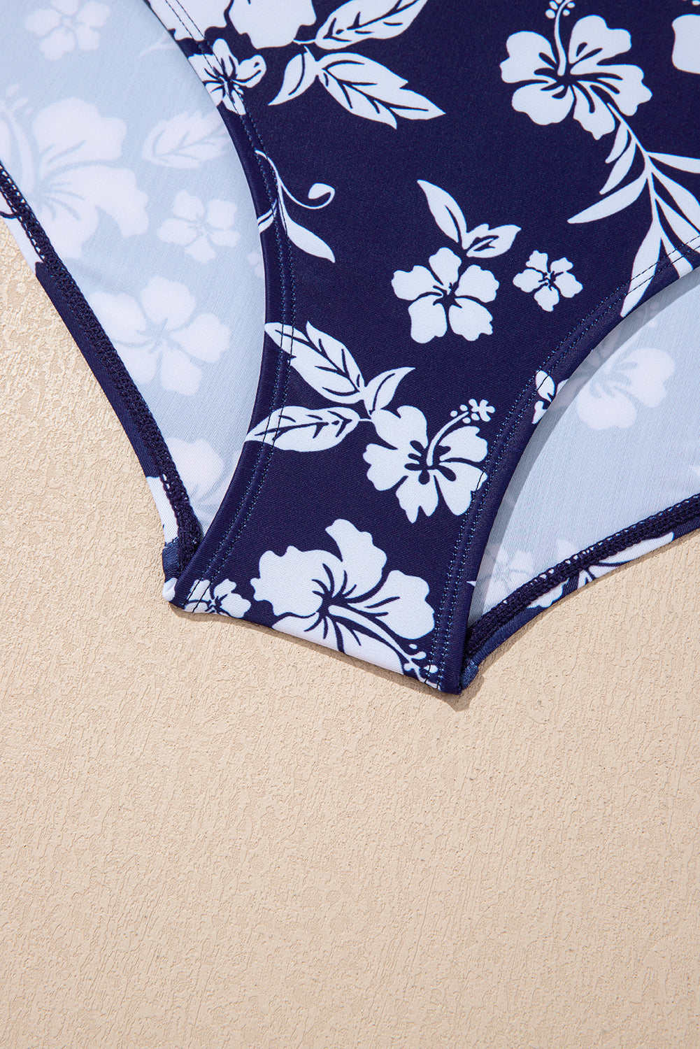 Traje de baño de una pieza con estampado floral, espalda cruzada azul y nudo lateral asimétrico