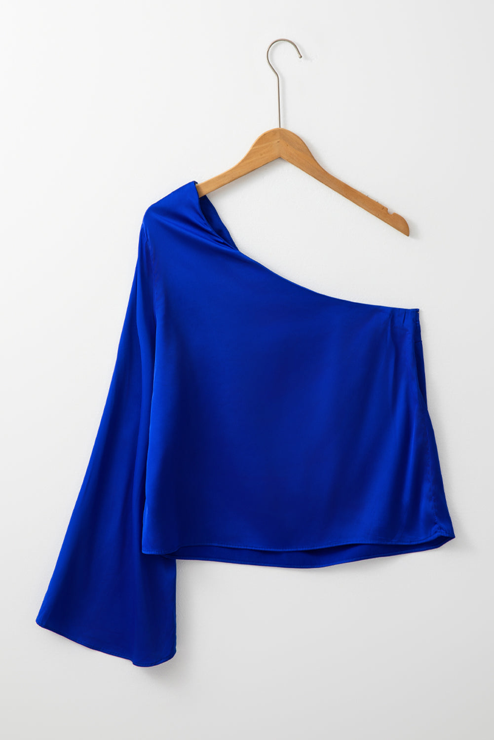 Blusa de satén asimétrica azul oscuro con una manga acampanada y un hombro al descubierto