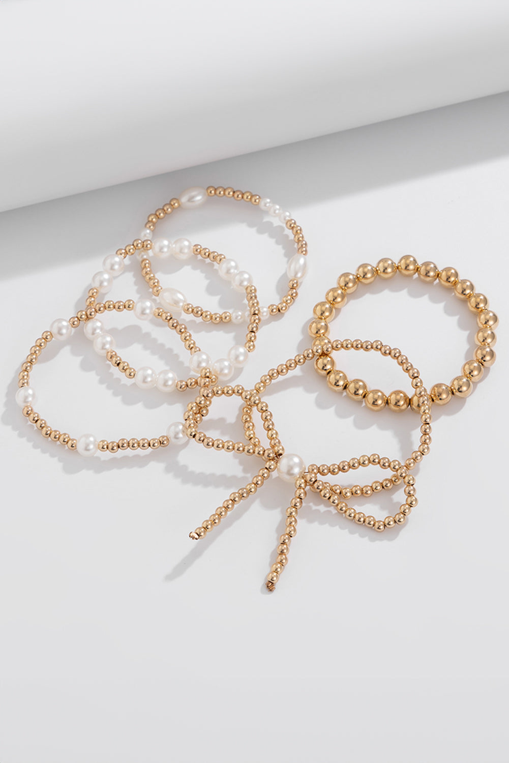 Set de pulseras de varias capas con cuentas de perlas y lazo dorado