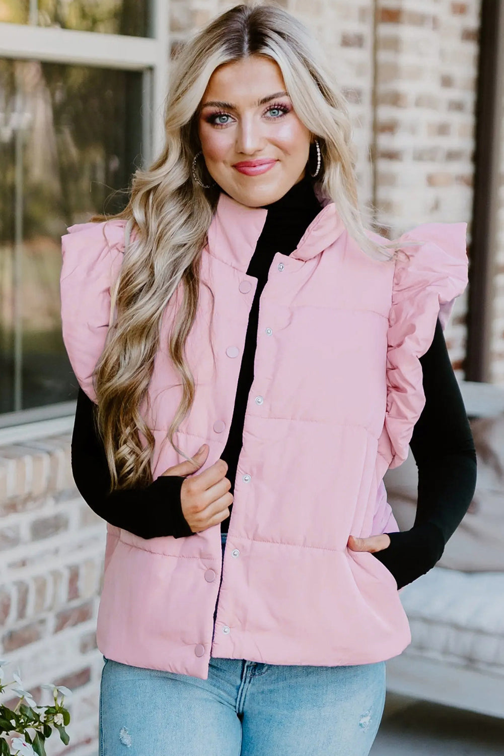 Chaleco acolchado rosa con cuello alto, mangas con volantes y botones a presión