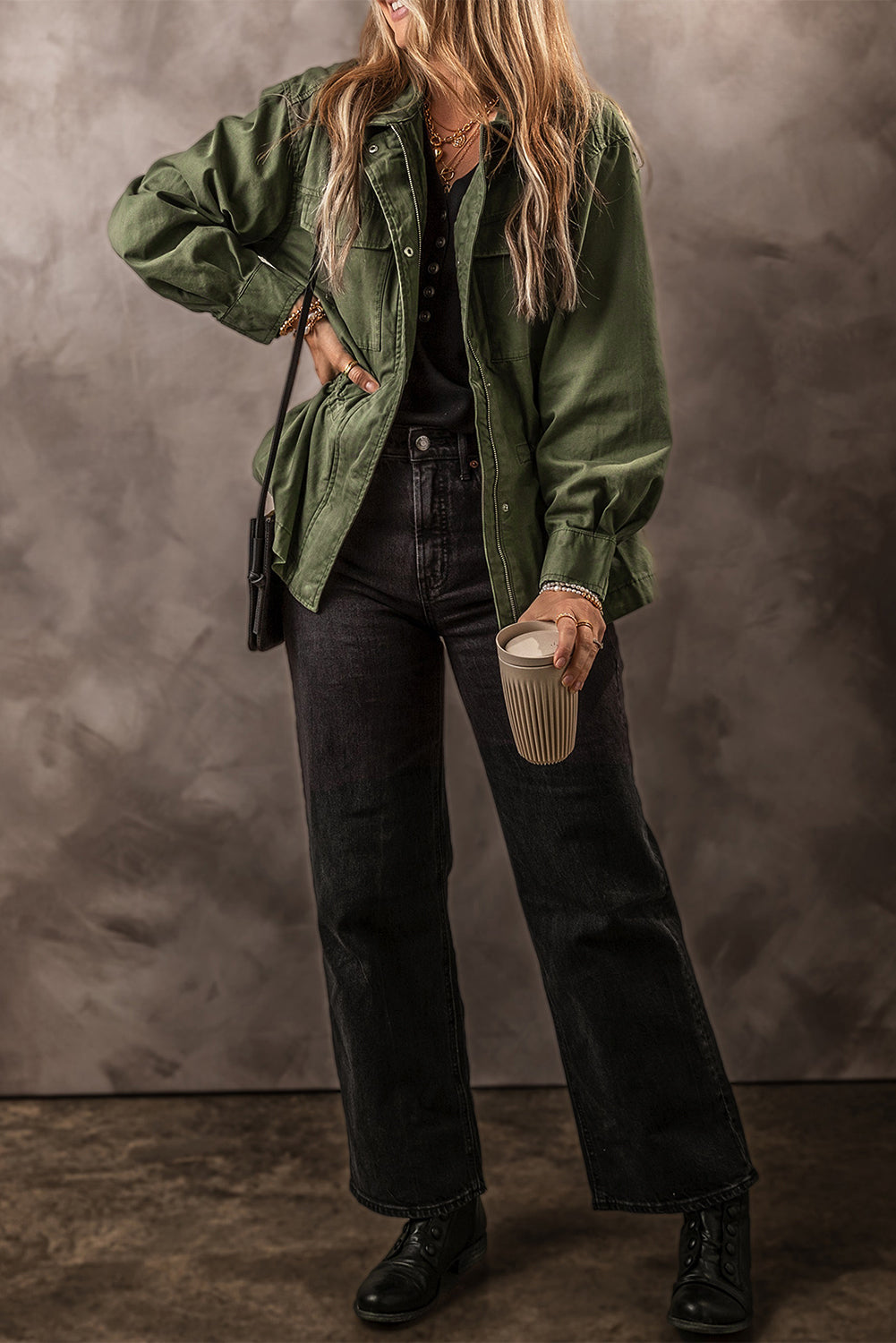 Chaqueta color verde musgo con cremallera, botones a presión, cintura ajustada y cuello.