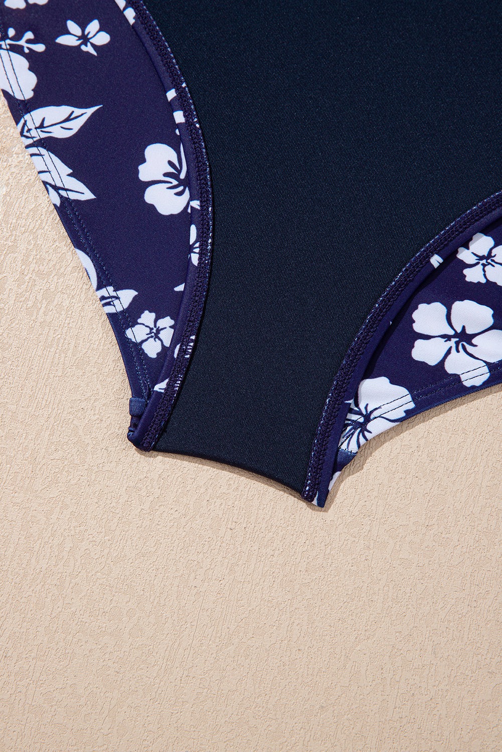 Traje de baño de una pieza con estampado floral, espalda cruzada azul y nudo lateral asimétrico