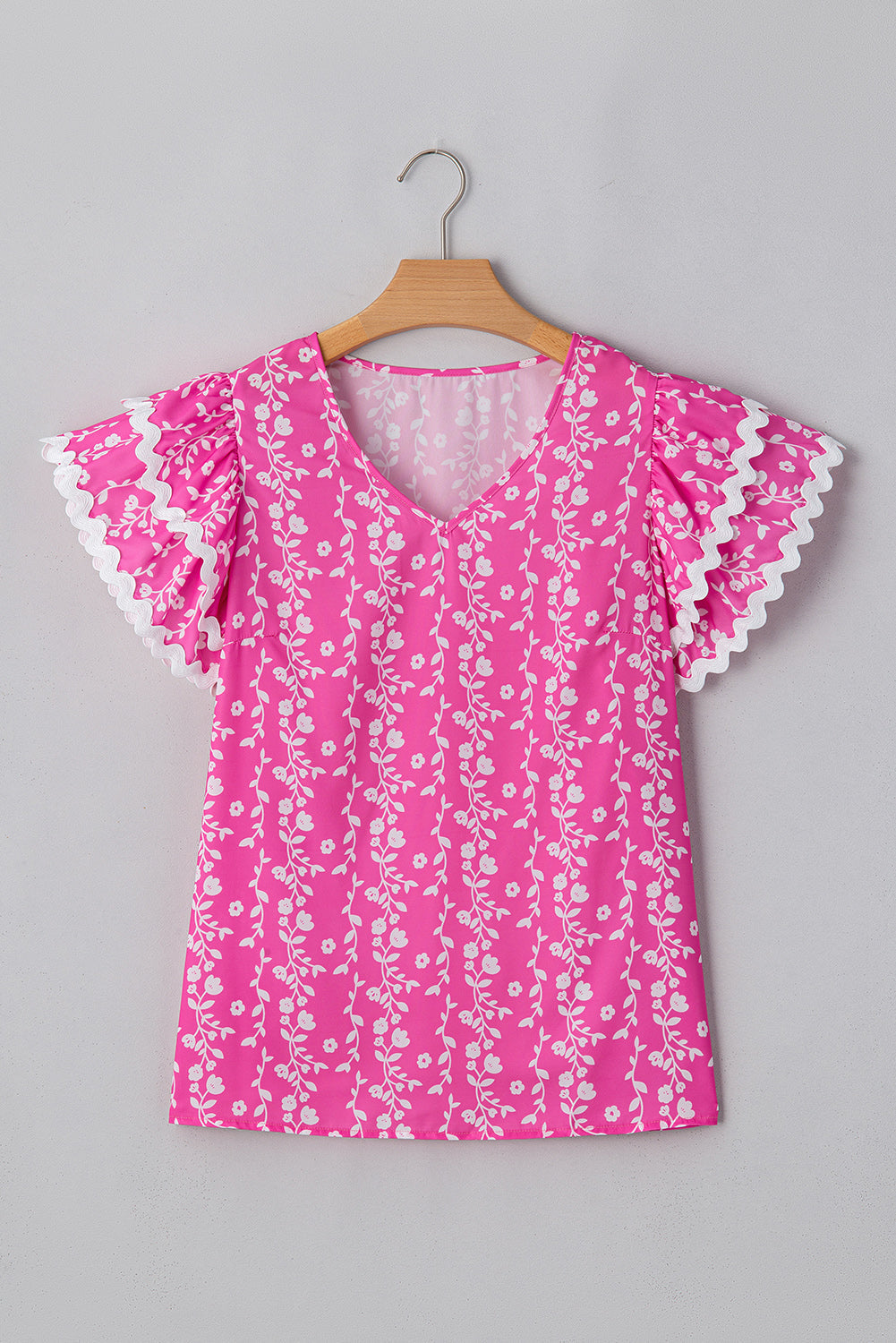 Blusa de cuello de pico con volantes escalonados y ribete de zig-zag con estampado floral rosa