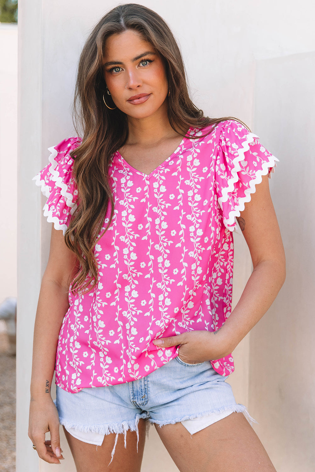 Blusa de cuello de pico con volantes escalonados y ribete de zig-zag con estampado floral rosa