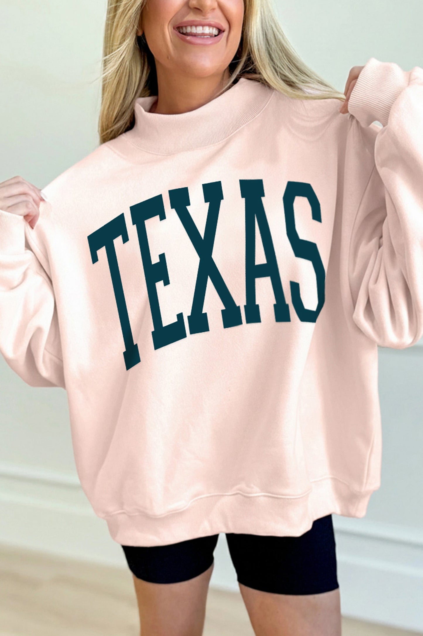 Sudadera holgada de cuello alto color albaricoque con letras de TEXAS estampadas