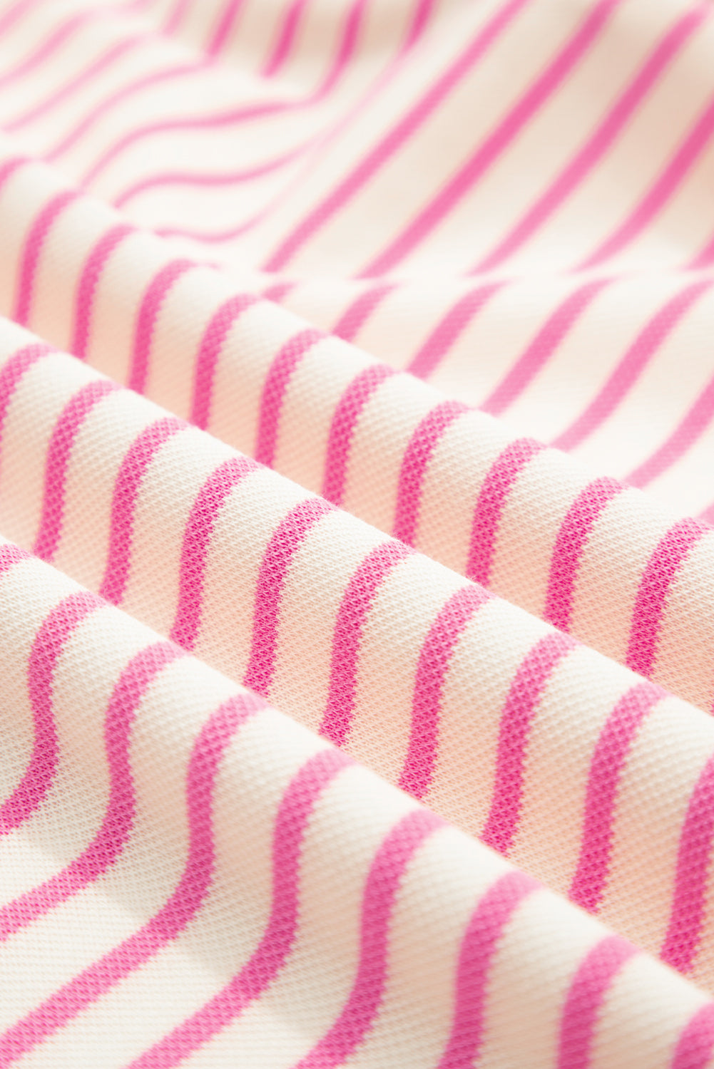 Top de manga corta con volantes a rayas y detalle en contraste rosa sobre rosa
