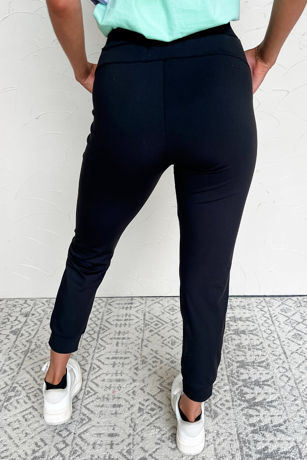 Pantalones joggers pitillo con cordón y detalles de costura expuesta, en color negro
