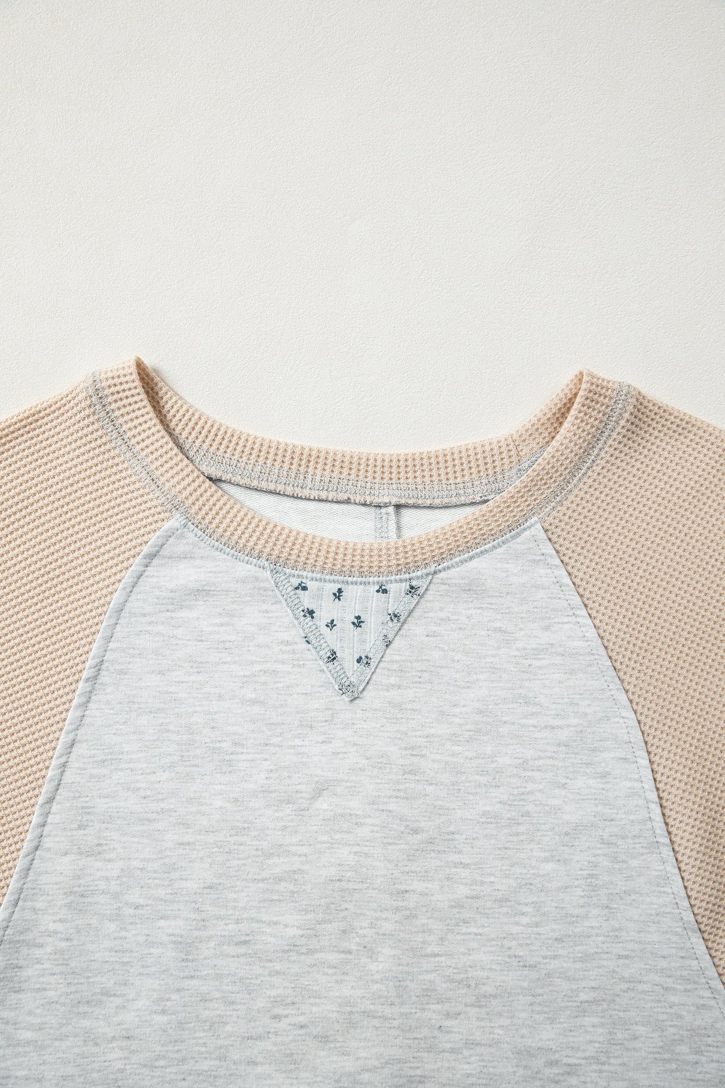 Camiseta tipo jersey de retales con costuras expuestas, manga raglán y estampado mixto gris claro