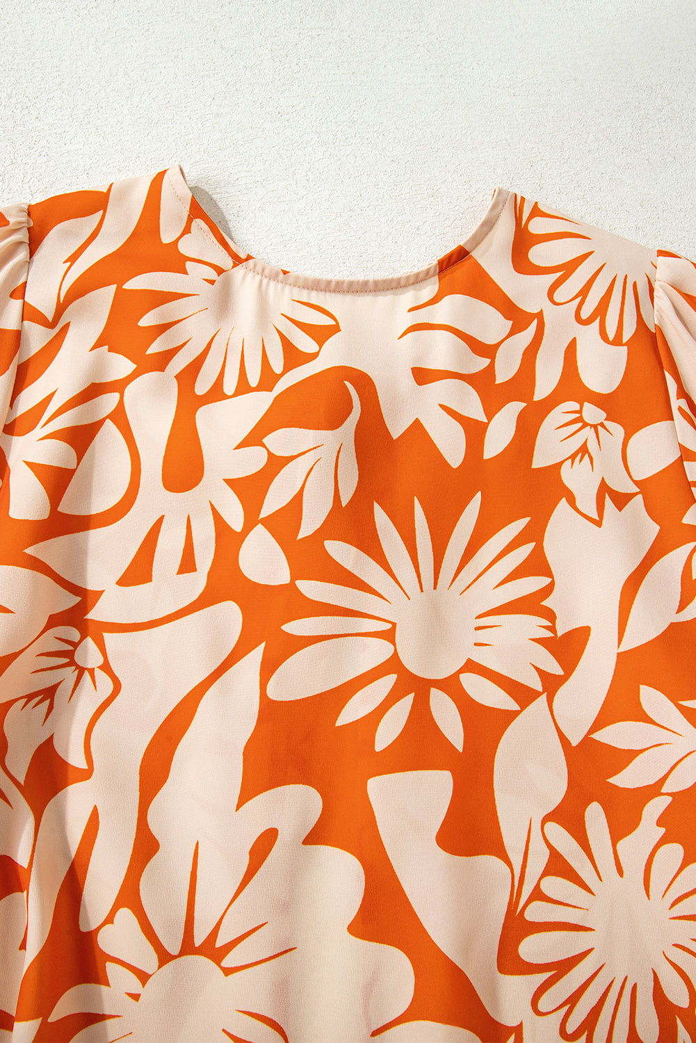 Blusa naranja de manga larga con estampado floral, nudo y espalda abierta