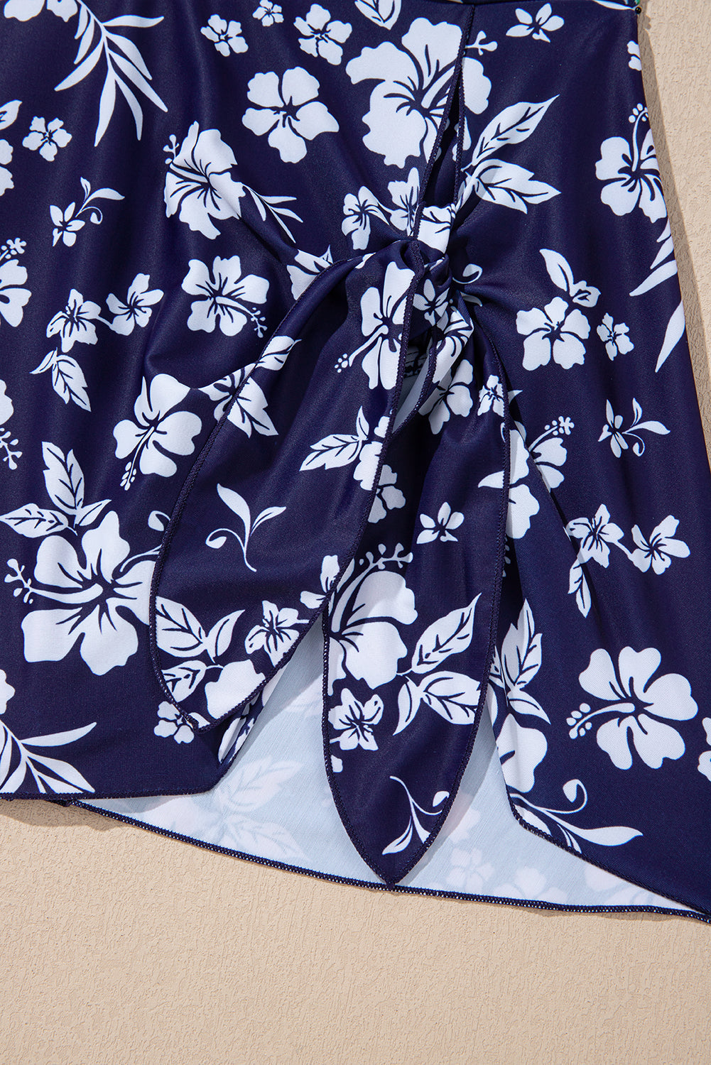 Traje de baño de una pieza con estampado floral, espalda cruzada azul y nudo lateral asimétrico