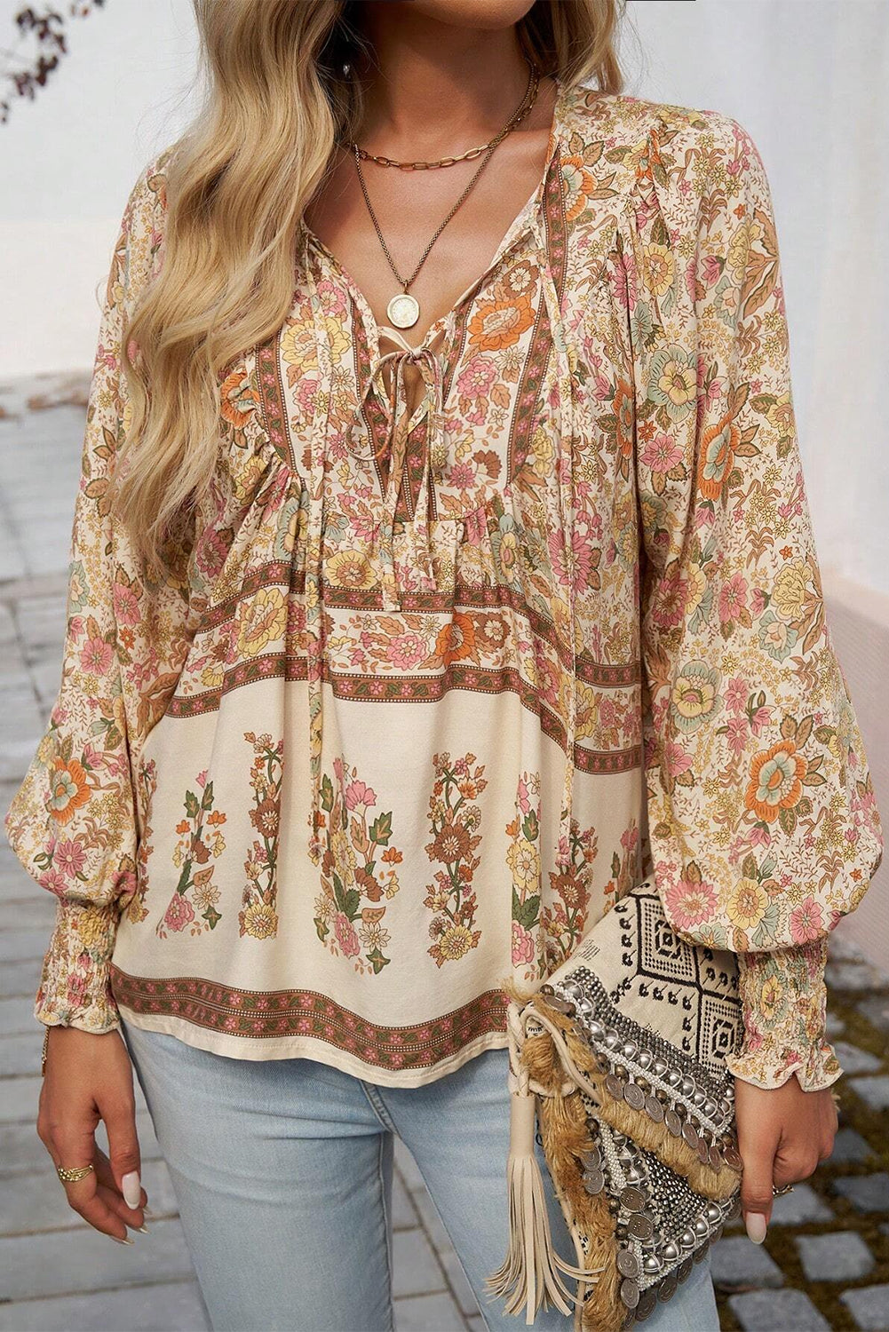 Blusa con estampado floral amarillo, lazo en el cuello y mangas farol