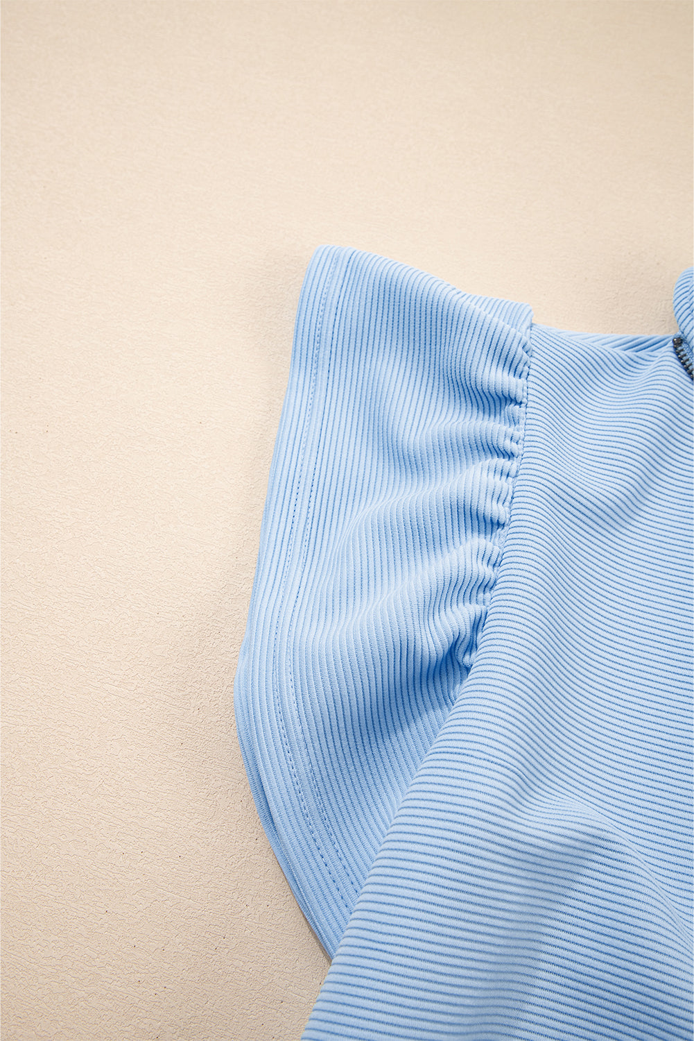 Conjunto de top con cremallera, mangas con volantes y textura azul cielo, y pantalón de pernera ancha