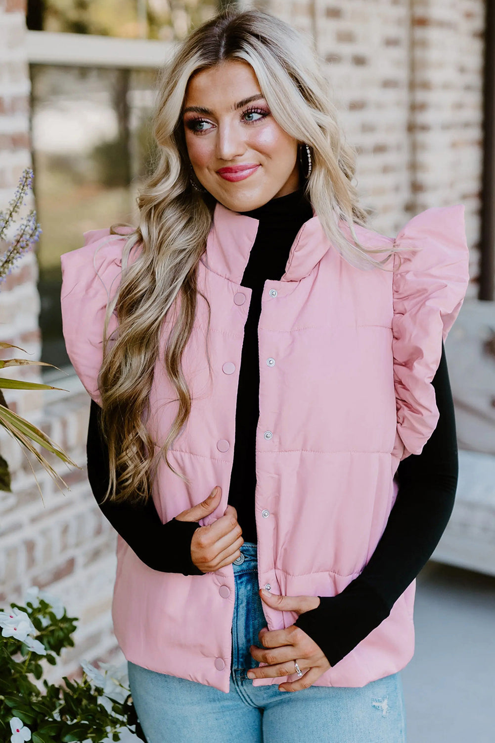 Chaleco acolchado rosa con cuello alto, mangas con volantes y botones a presión