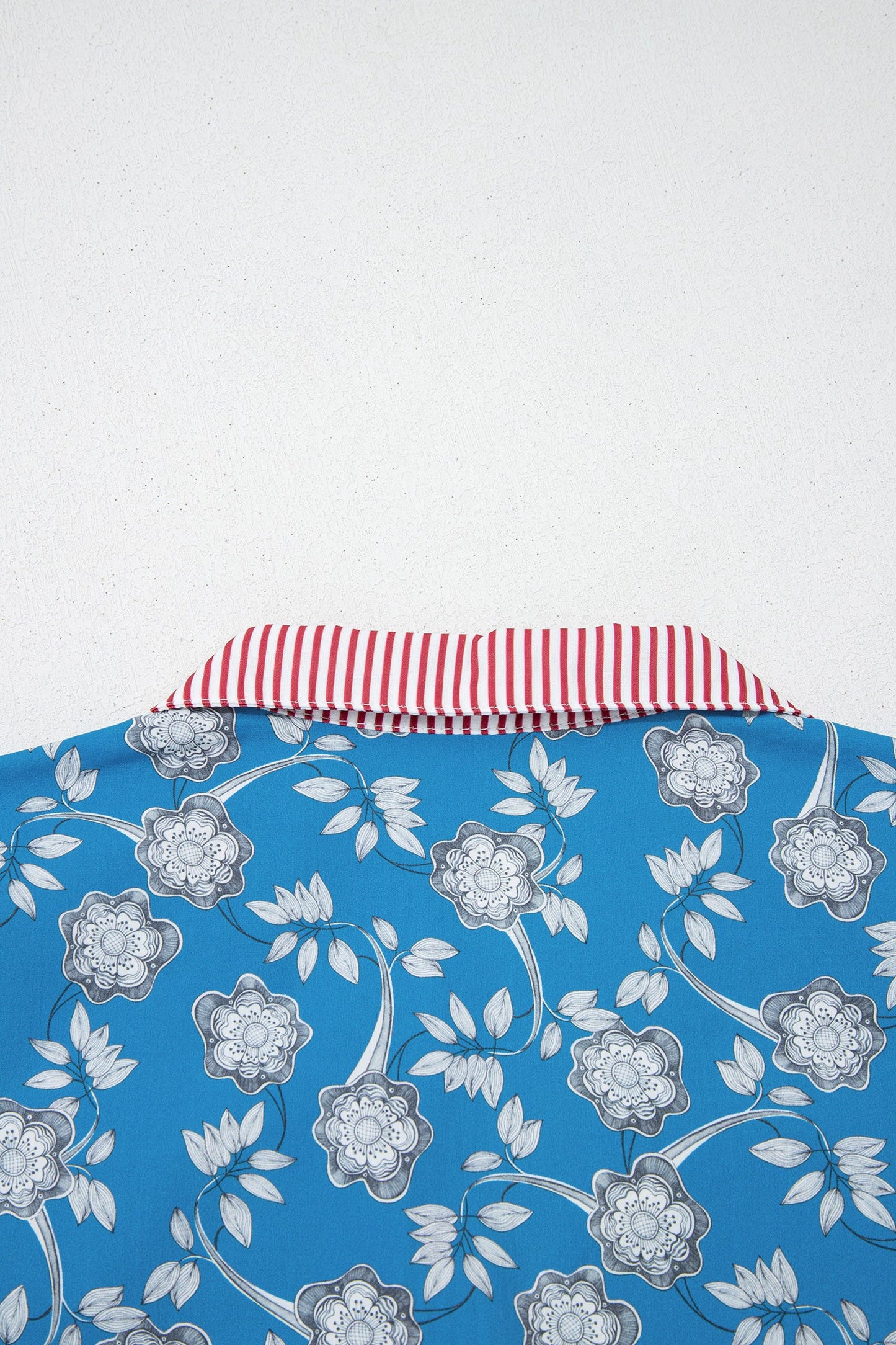 Blusa de manga corta con cuello abotonado, ribete a rayas y estampado floral retro azul