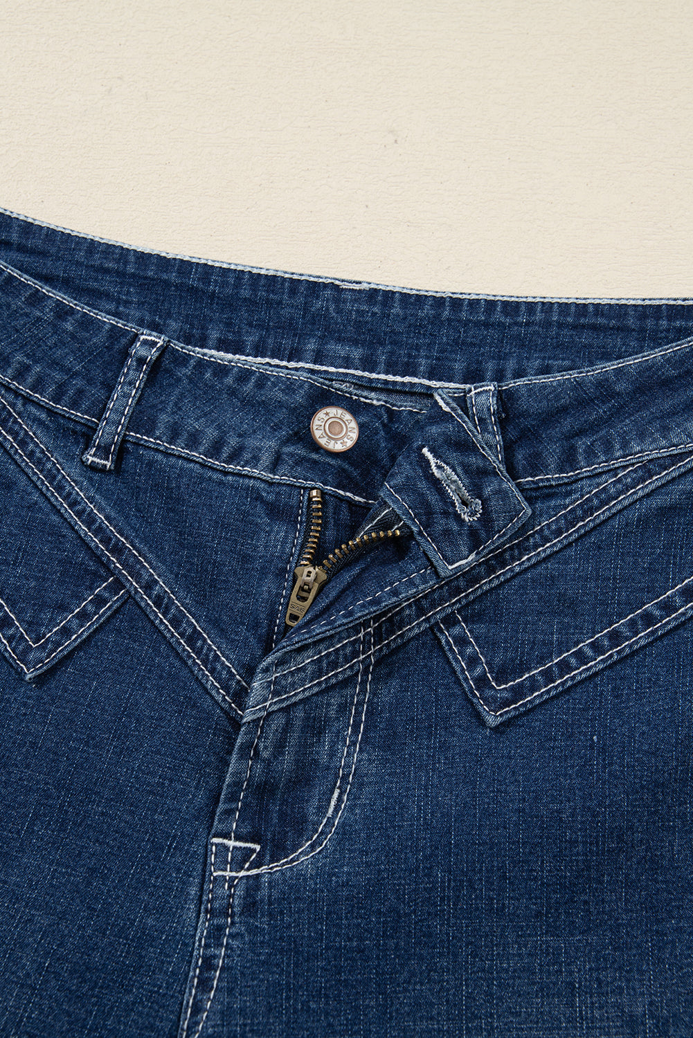 Vaqueros azules con pespuntes, detalle en la cintura y dobladillo vuelto