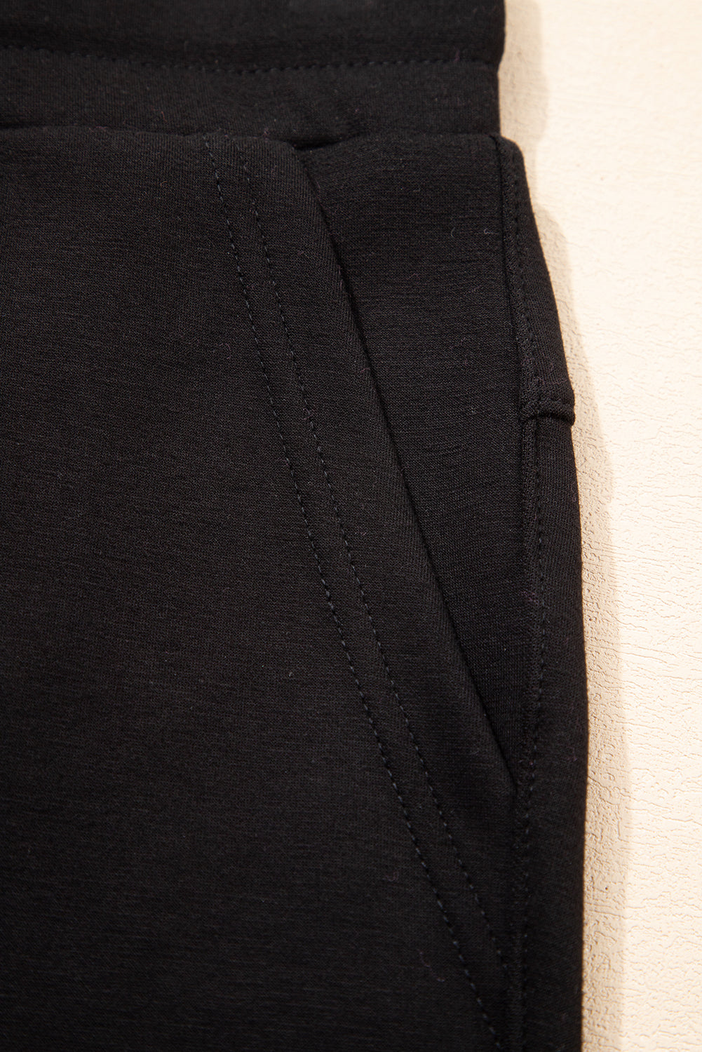 Pantalones joggers pitillo con cordón y detalles de costura expuesta, en color negro