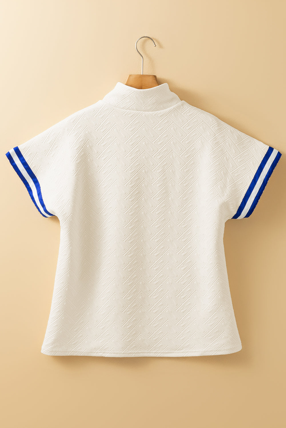 Top de manga corta con cremallera de un cuarto, diseño color block, textura con rayas preppy, color beige