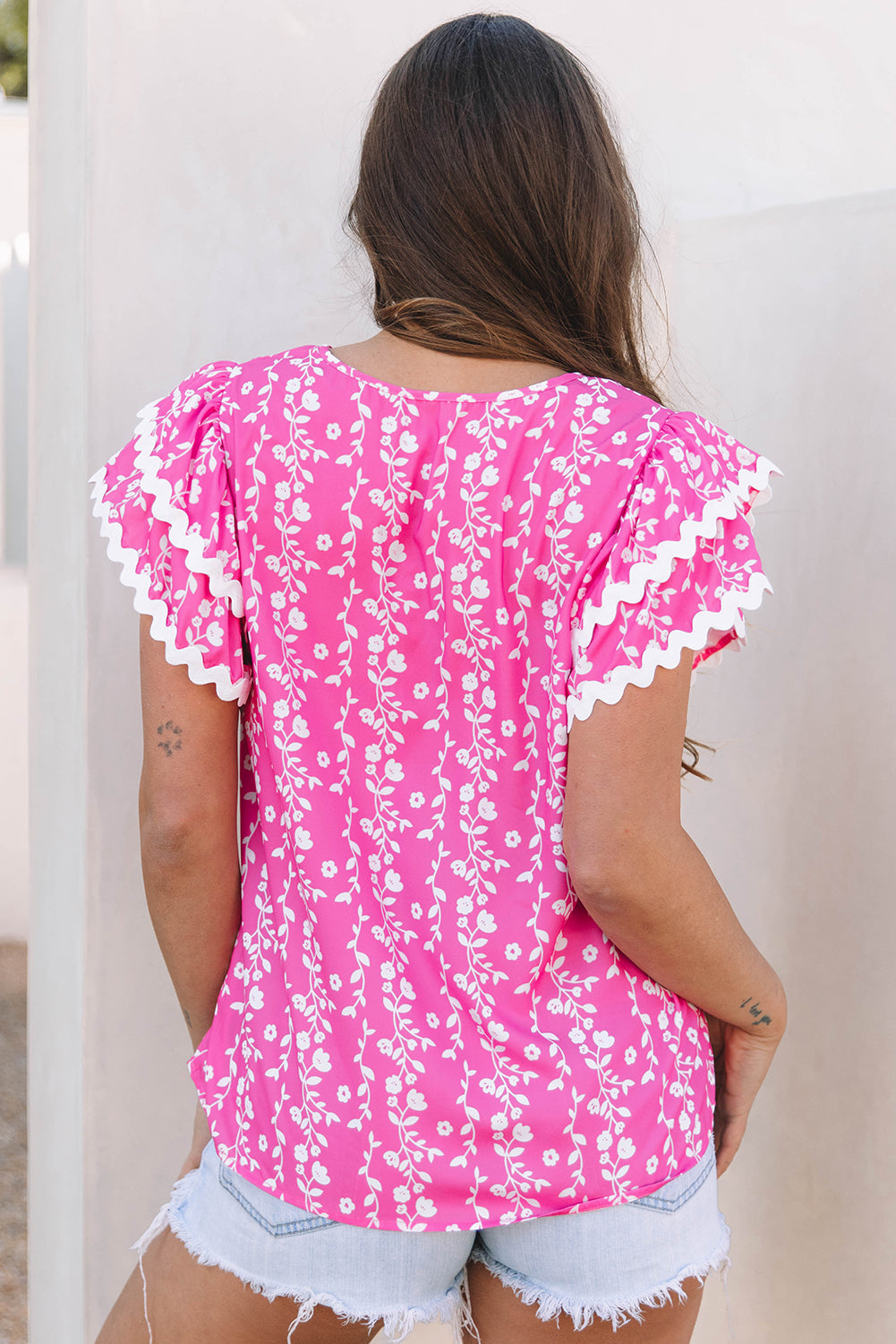 Blusa de cuello de pico con volantes escalonados y ribete de zig-zag con estampado floral rosa