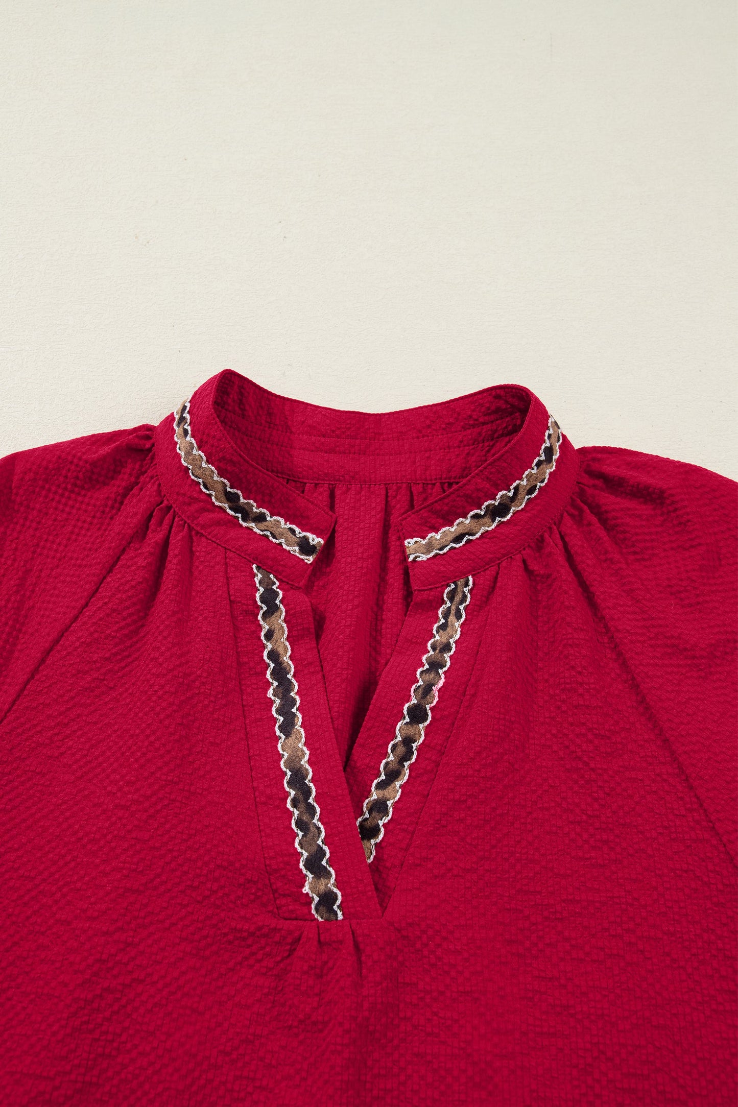 Blusa texturizada con cuello en V y estampado de jacquard de leopardo rojo de carreras