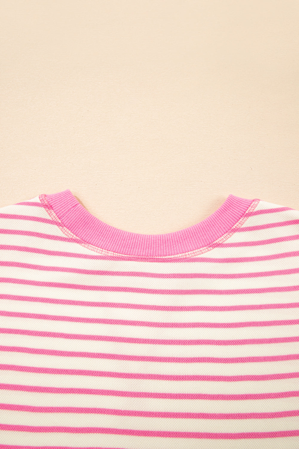 Top de manga corta con volantes a rayas y detalle en contraste rosa sobre rosa