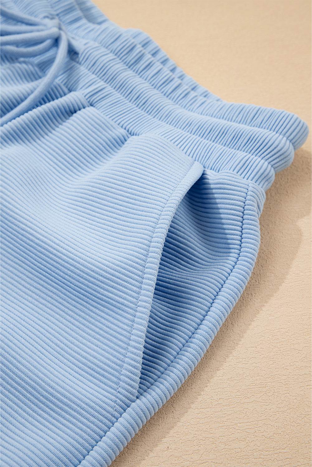 Conjunto de top con cremallera, mangas con volantes y textura azul cielo, y pantalón de pernera ancha