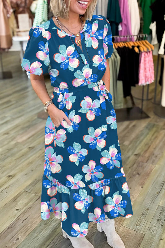 Vestido largo azul con estampado floral, manga corta abullonada, bajo con volantes y cinturón