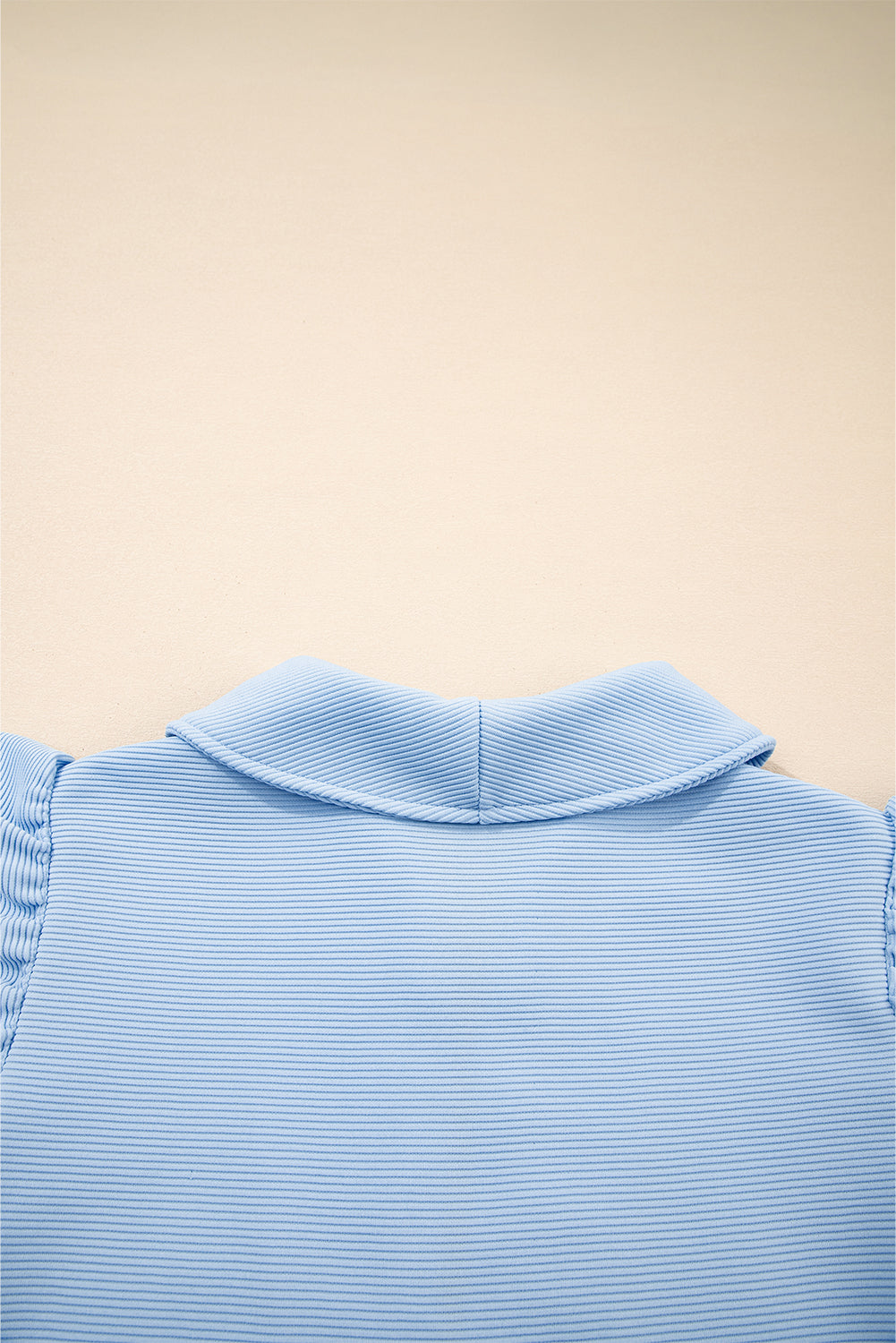 Conjunto de top con cremallera, mangas con volantes y textura azul cielo, y pantalón de pernera ancha