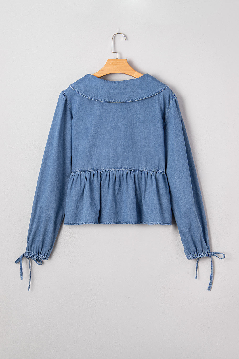Top péplum atado con manga globo, cuello solapa y denim azul anochecer