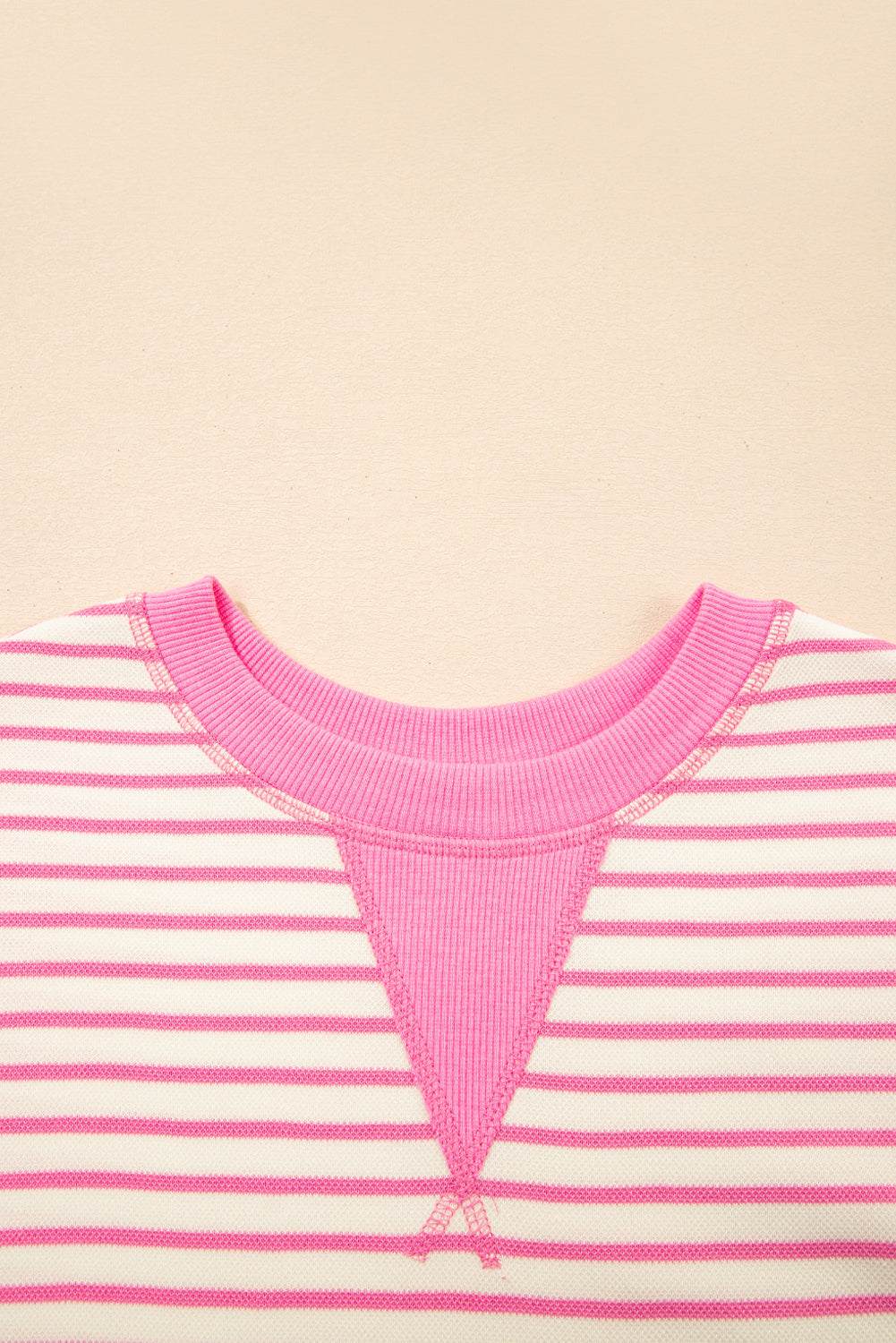 Top de manga corta con volantes a rayas y detalle en contraste rosa sobre rosa