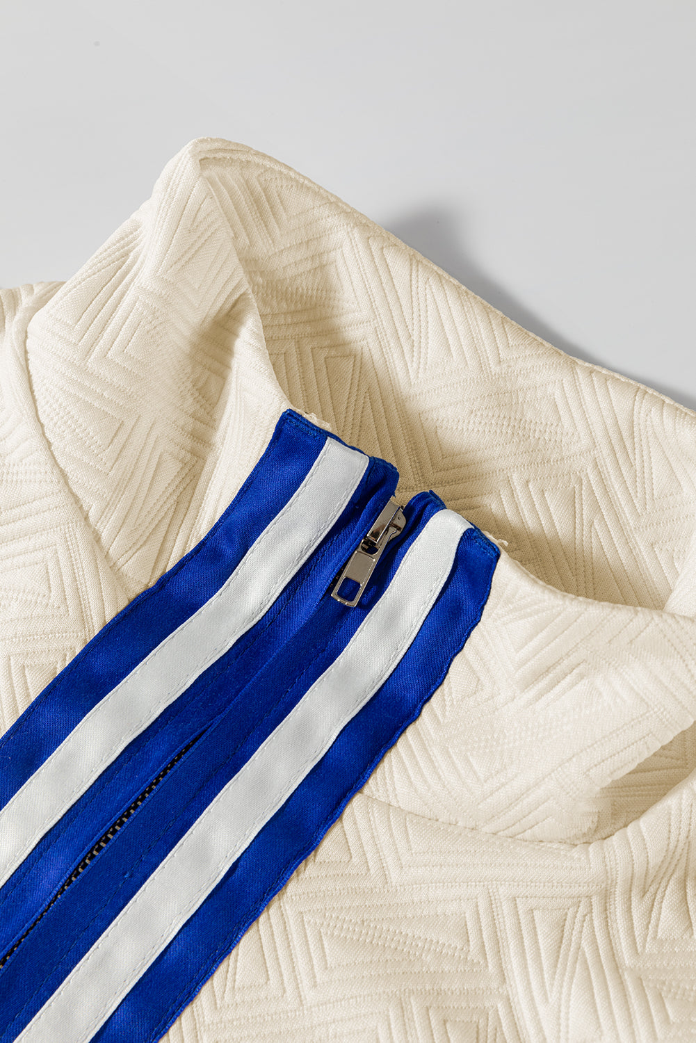 Top de manga corta con cremallera de un cuarto, diseño color block, textura con rayas preppy, color beige