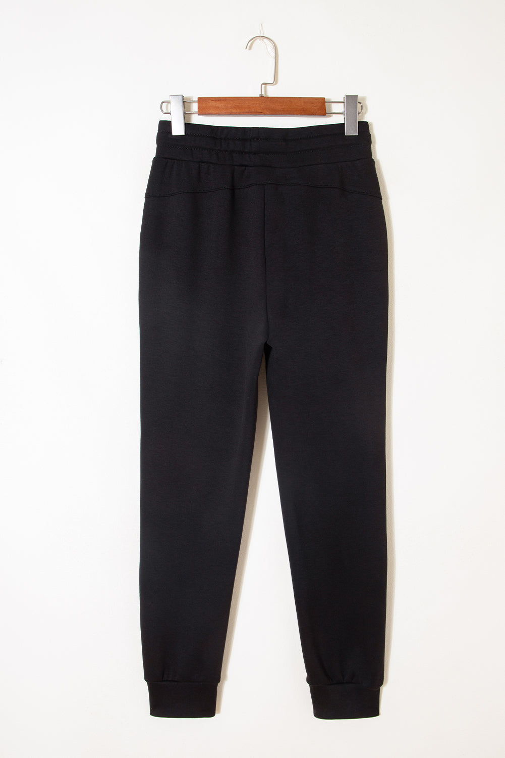 Pantalones joggers pitillo con cordón y detalles de costura expuesta, en color negro