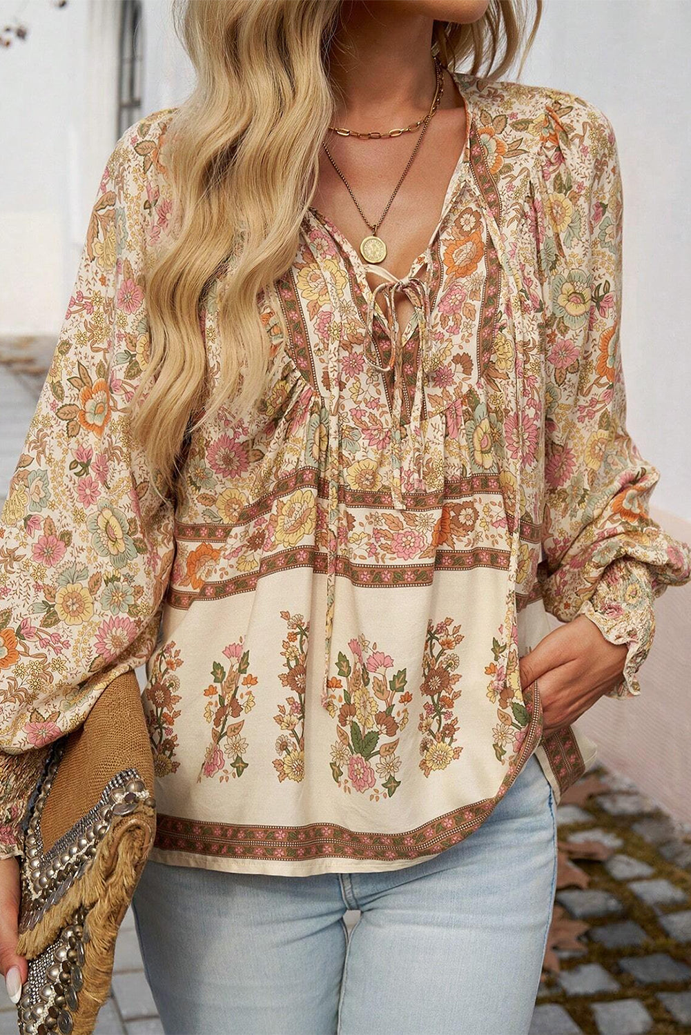 Blusa con estampado floral amarillo, lazo en el cuello y mangas farol