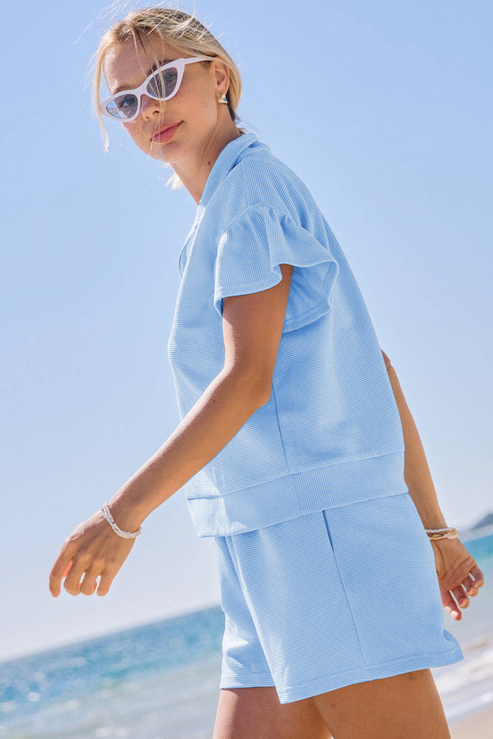 Conjunto de top y shorts Beau azules con textura acanalada, media cremallera y mangas cortas con volantes