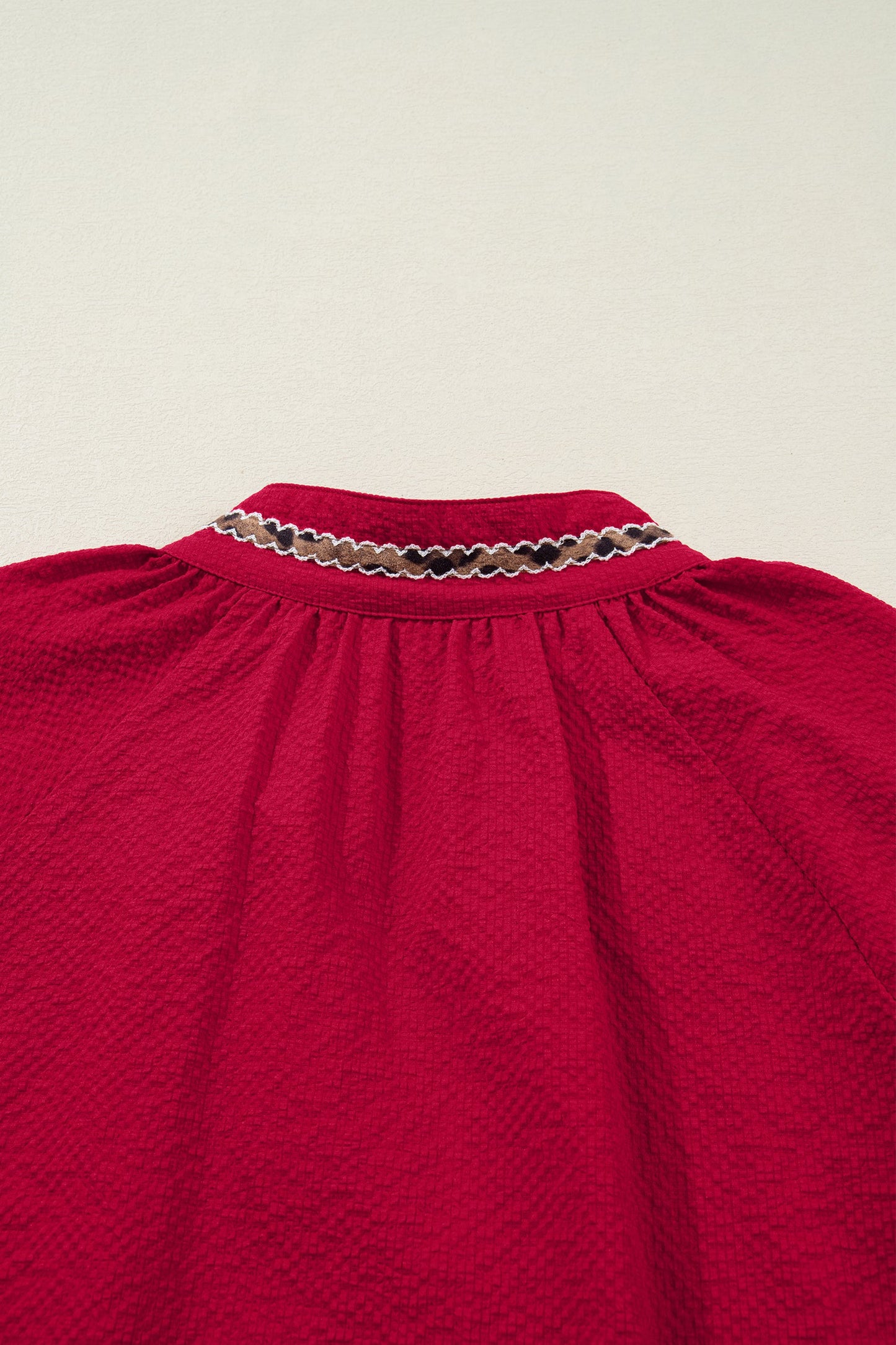 Blusa texturizada con cuello en V y estampado de jacquard de leopardo rojo de carreras