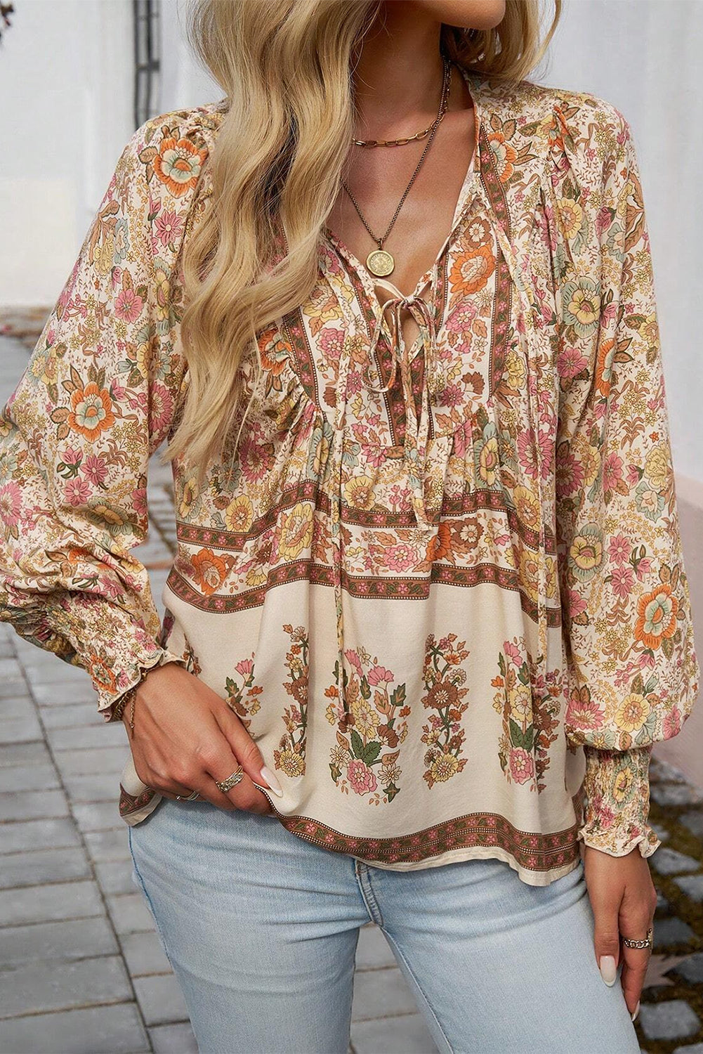 Blusa con estampado floral amarillo, lazo en el cuello y mangas farol