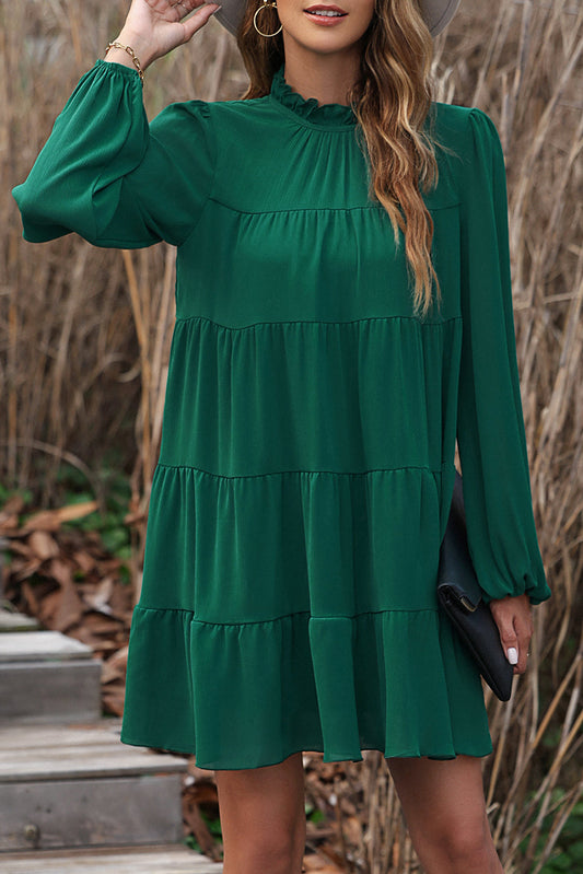 Vestido escalonado verde con cuello simulado, manga abullonada y nudo en la espalda