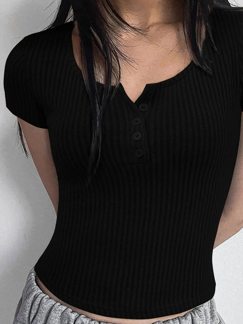 Camiseta de manga corta con cuello redondo, detalle de botones y textura acanalada