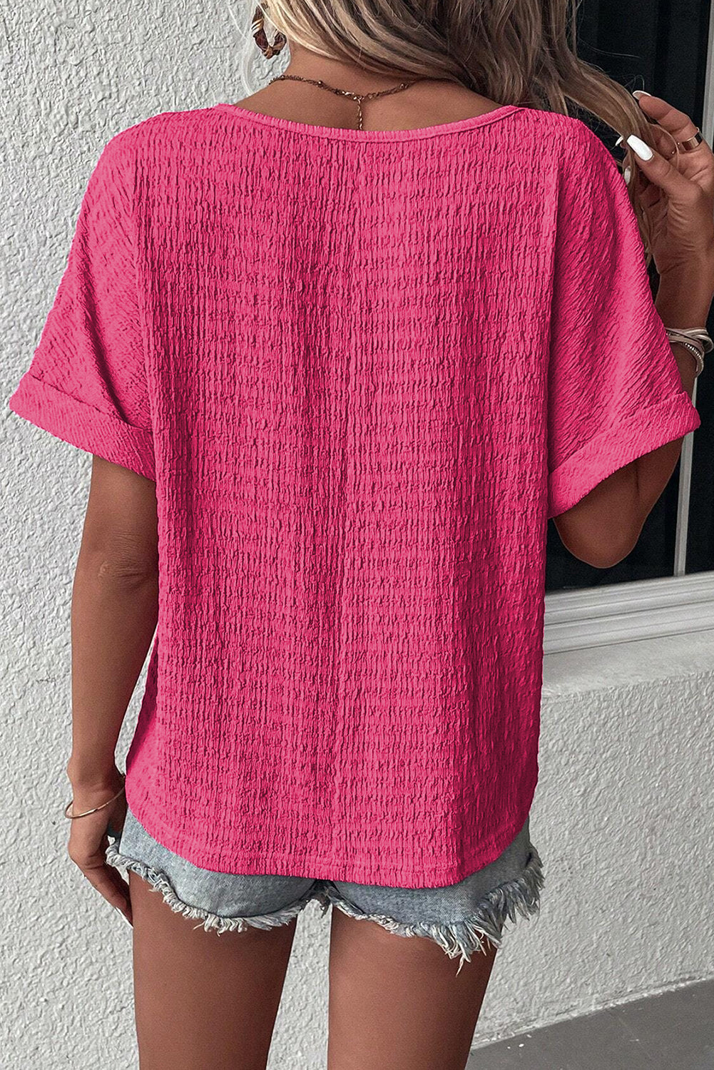 Camiseta rosa vivo texturizada con cuello de pico y mangas enrolladas
